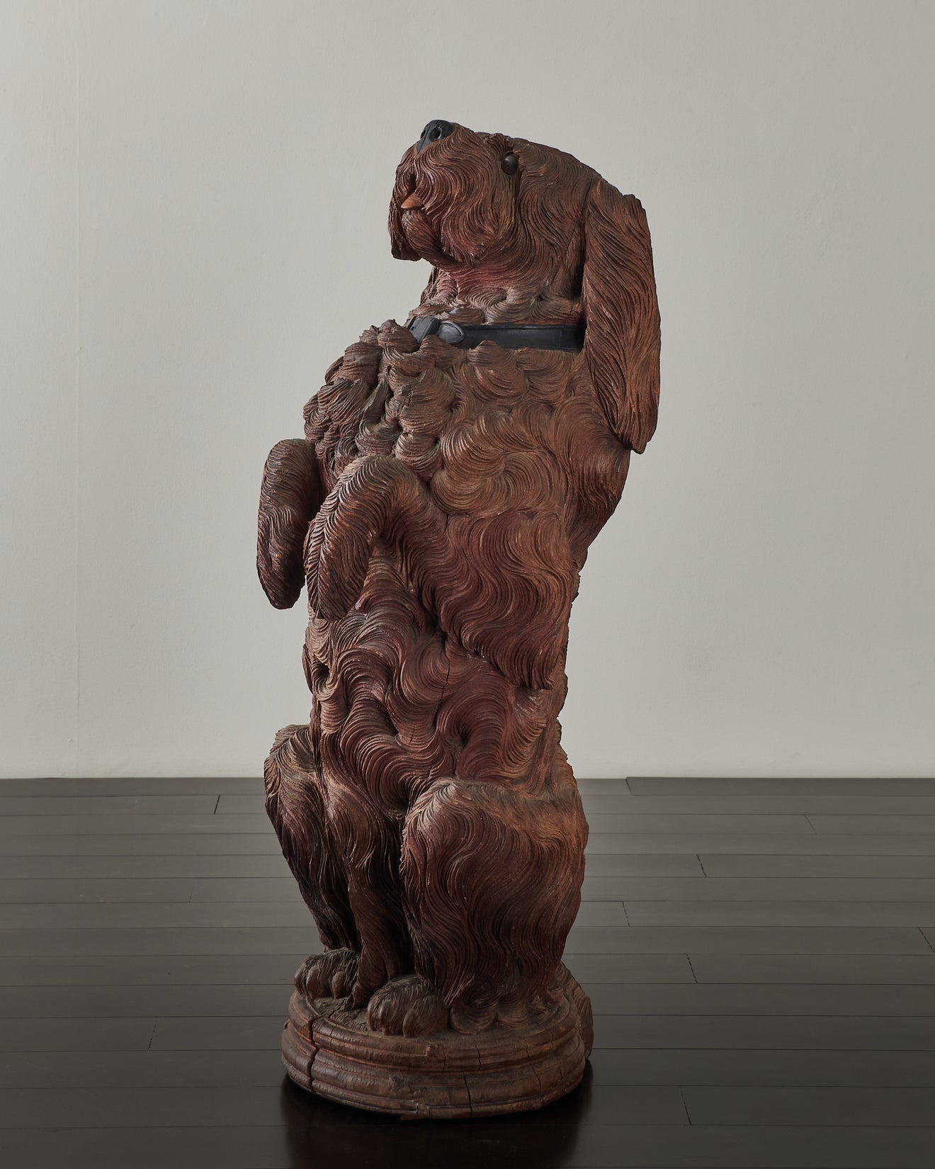 A Black Forest carved life-size begging dog figure
